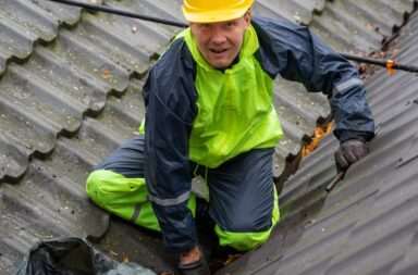 Construction worker on a rooftop ensuring safety with helmet and gear.