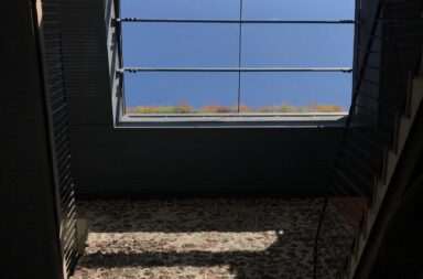 a room with a window and a rug on the floor
