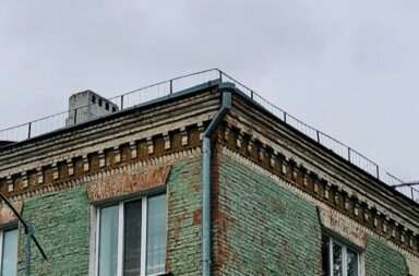 a tall green building with lots of windows