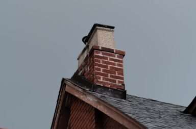 A red brick building with a black roof and a chimney